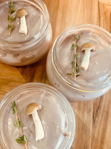Smooth mushroom and thyme pâté, garnished with fresh thyme sprigs and served with crusty bread.